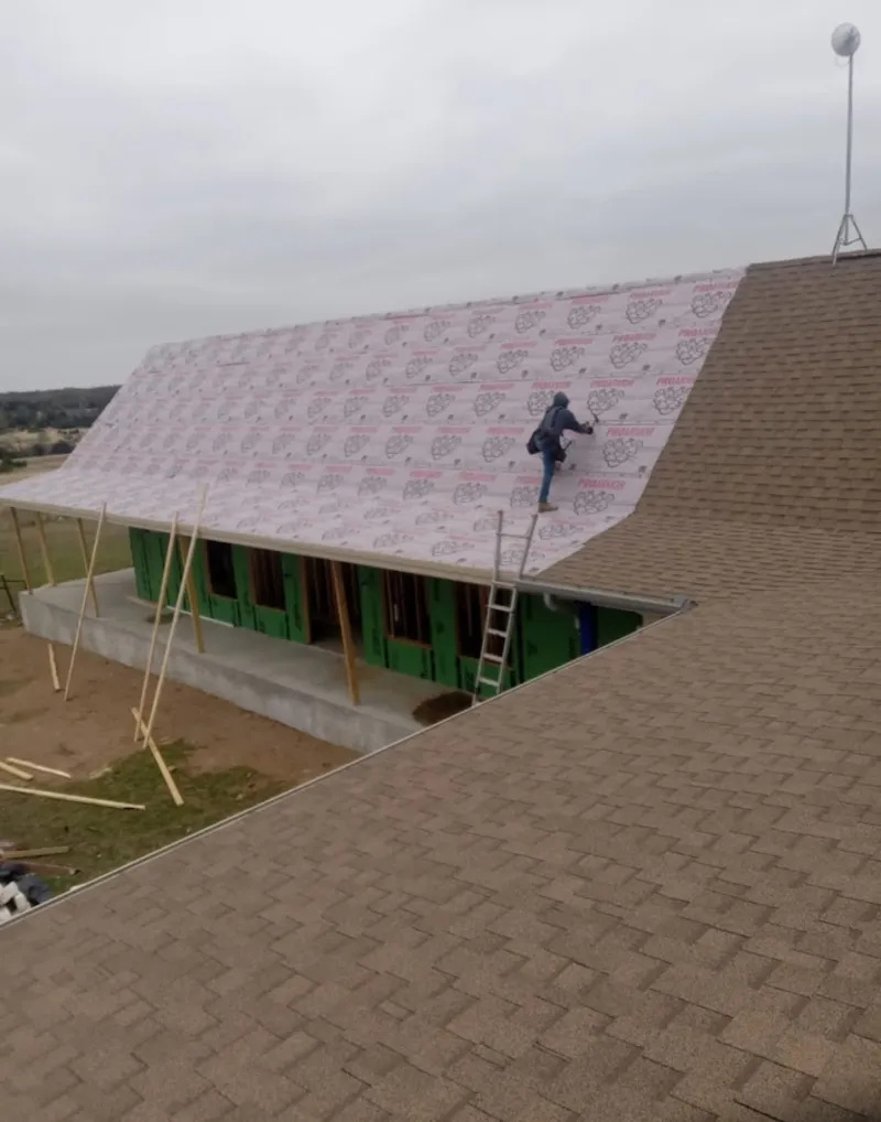 Worker preparing underlayment for a metal roof installation in Waukesha